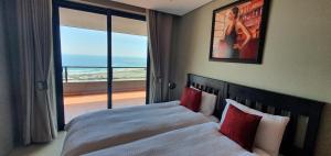 a bedroom with a bed with a view of the ocean at Accommodation Front - Immaculate 4 Sleeper with Ocean & Harbour Views in Durban