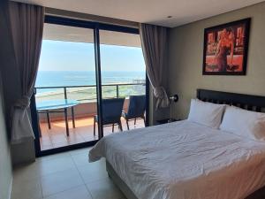 a bedroom with a bed and a view of the ocean at Accommodation Front - Immaculate 4 Sleeper with Ocean & Harbour Views in Durban
