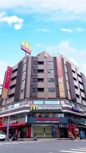 a large building with a mcdonalds sign on top of it at Talmud Hotel Yizhong in Taichung