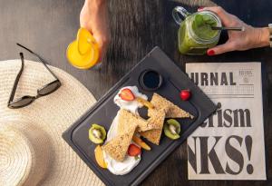 a plate of nachos with fruit and a drink at Mitsis Selection Blue Domes in Kardamaina