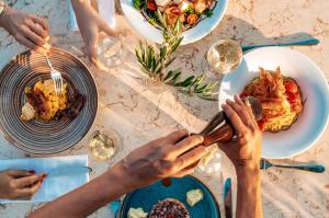 a group of people sitting at a table with food at Mitsis Selection Blue Domes in Kardamaina
