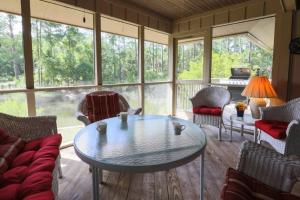 eine abgeschirmte Veranda mit einem Tisch und Stühlen in der Unterkunft Spriggs Shack in Kiawah Island