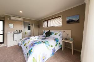 a bedroom with a large bed and a kitchen at BigSky Bed and Breakfast in Omarama