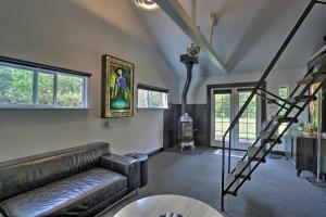 a living room with a leather couch and a staircase at Modern Entertainment Getaway Off Sacramento River! in Anderson