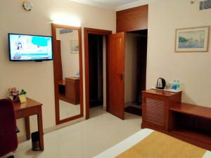 a hotel room with a television and a bed at Raj Park- Hill View in Tirupati