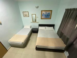 A bed or beds in a room at Hotel Permai