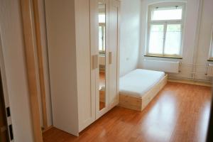 Habitación pequeña con cama y espejo. en U Broučků en Lipova Lazne