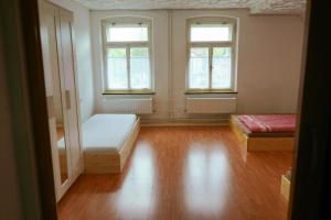 an empty room with two beds and two windows at U Broučků in Lipova Lazne