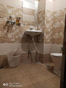 een badkamer met een wastafel en een toilet bij Hotel Sudarshan in Haridwār