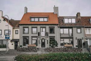 een groot huis met een oranje dak op een straat bij Hotel Bell in Zandvoort