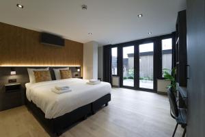 a bedroom with a large bed and a large window at Hotel Bell in Zandvoort