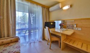 Habitación de hotel con escritorio y ventana en Flamingo Hotel 4*, en Albena