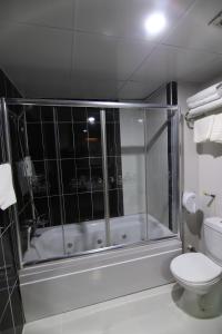 La salle de bains est pourvue d'une douche, de toilettes et d'une baignoire. dans l'établissement SARDUR HOTEL, à Bostaniçi