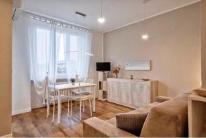 ein Wohnzimmer mit einem Sofa und einem Tisch mit Stühlen in der Unterkunft Andreis 3 in Turin