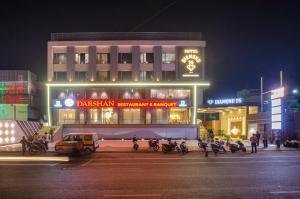 a building with motorcycles parked in front of it at night at Hotel Diamond 26 in Surat