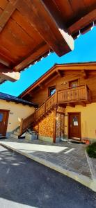 Casa grande con porche de madera y escaleras en Casa da Claudia, en Livigno
