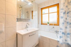 een badkamer met een wastafel, een bad en een douche bij Allgäuglück in Sonthofen