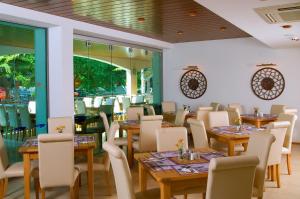un ristorante con tavoli e sedie in legno e finestre di Flamingo Hotel 4* ad Albena