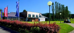 ein Gebäude mit Flaggen und Blumen in einem Park in der Unterkunft Hotel Hausschachen in Weitra