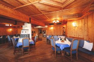 una sala da pranzo con tavoli, sedie e pareti in legno di Roanwirt a Sankt Lorenzen im Mürztal