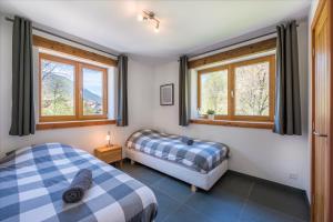 two beds in a room with windows at Ski and bike - holiday home Verbier Valley in Versegeres 