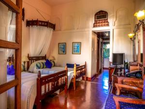 a living room with a large bed and a television at Zanzibar Serena Hotel in Zanzibar City