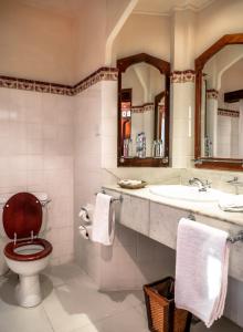 a bathroom with a toilet a sink and a bath tub at Zanzibar Serena Hotel in Zanzibar City