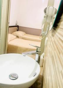 a bathroom with a sink and a phone on a wall at Hotel La Primula in Corigliano Calabro +22 photos