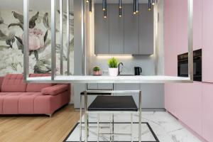 ワルシャワにあるPremium Apartments Business Center by Renters Prestigeのピンクのソファとピンクのテーブル付きのキッチン
