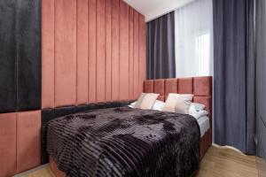 a bedroom with a bed with a red wall at Premium Apartments Business Center by Renters Prestige in Warsaw