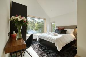 a bedroom with a bed and a table with a vase of flowers at Portnellan in Crianlarich