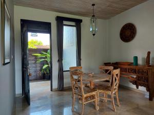 jadalnia z drewnianym stołem i krzesłami w obiekcie Bali Sila Bisma w mieście Ubud