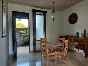 uma sala de jantar com uma mesa de madeira e cadeiras em Bali Sila Bisma em Ubud