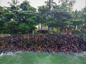 a rock wall next to a body of water at Sea Hut Homestay in Cochin