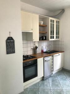 een keuken met witte kasten en een fornuis met oven bij LES ÎLES - Parking, Balcon, Netflix & PS4! in Annecy