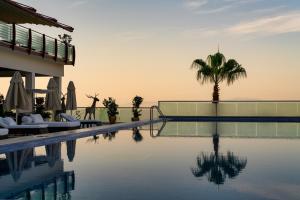 a villa with a swimming pool and a palm tree at Hillstone Bodrum Hotel & Spa in Bodrum City