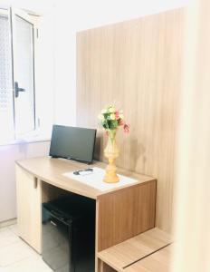 a desk with a vase of flowers on top of it at Hotel La Primula in Corigliano Calabro