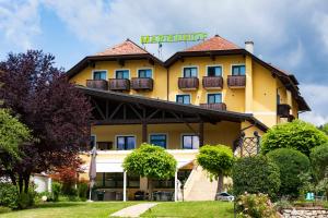 un edificio giallo con un cartello sopra di Vitalhotel Marienhof a Velden am Wörthersee