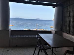 a window with a table and a view of the ocean at Casa Agave - villetta sul mare a Salina, Isole Eolie in Malfa