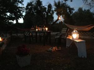 uma mesa de piquenique com luzes no quintal à noite em Chateaux des Trulli em San Michele Salentino