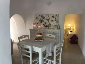 a dining room with a table with a bowl of fruit on it at Chateaux des Trulli in San Michele Salentino
