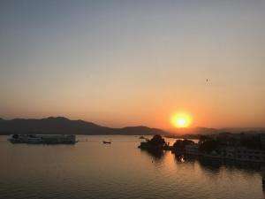 
a large body of water with a sunset at Jaiwana Haveli in Udaipur
