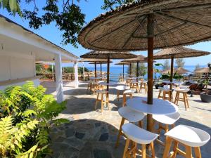 eine Gruppe von Tischen und Stühlen mit Sonnenschirmen in der Unterkunft Malama Beach Holiday Village in Protaras