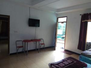 una sala de estar con una mesa y dos sillas en Lembah Biru Lagoon, en Mandai