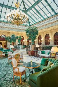 un grand hall avec des canapés, des tables et un lustre dans l'établissement InterContinental Paris Le Grand, an IHG Hotel, à Paris