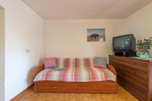 una camera con letto e TV su un comò di AffittaSardegna-Casa Coppia 2 a Costa Corallina