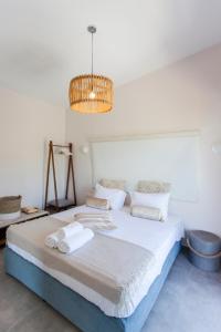 1 dormitorio con 1 cama grande y lámpara de araña en VILLA LUCA, en Katokhórion