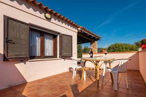 un patio con tavolo e sedie sul balcone. di AffittaSardegna-Casa Coppia 2 a Costa Corallina