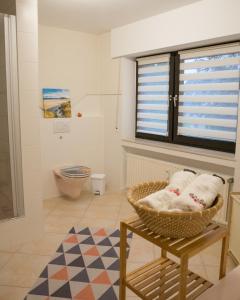 a bathroom with a toilet and a basket of towels at Schöne Ferienwohnung in Kürten in Kürten