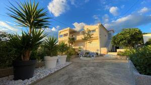 a house with palm trees in front of it at Trogir center exclusive seaview apartment for 4 in Trogir